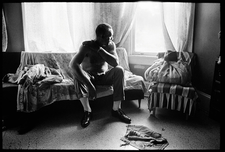 Zdjęcie z albumu Tell It Like It Is, fot. David Alan Harvey"James Liggins, głowa rodziny, siedzi na kanapie bez koszuli"